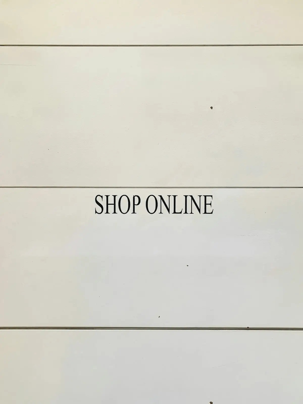The image shows a minimalist off-white background with bold black serif text prompting users to shop trending electronics and fashion online.
