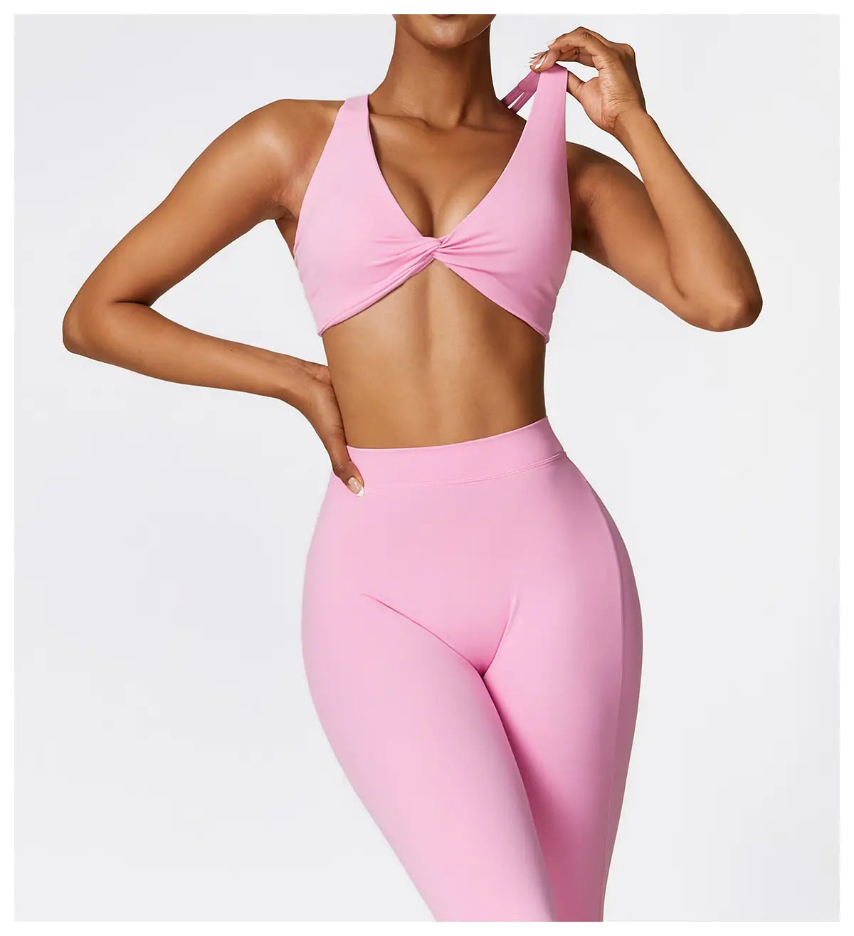 pink athletic two-piece set featuring a twisted front detail on the top and high-waist flared yoga pants ideal for activewear and yoga sessions