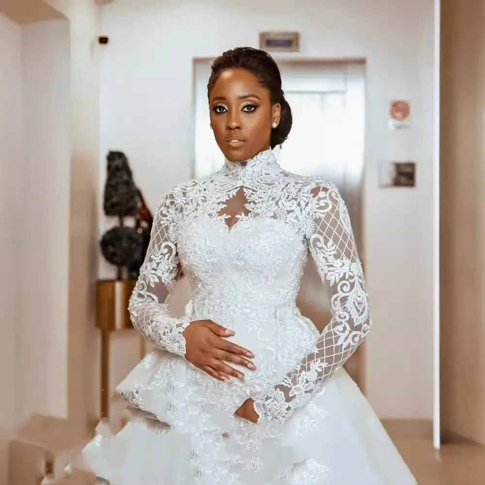 A white floral lace wedding gown with a stand collar long sleeves and a high neckline.