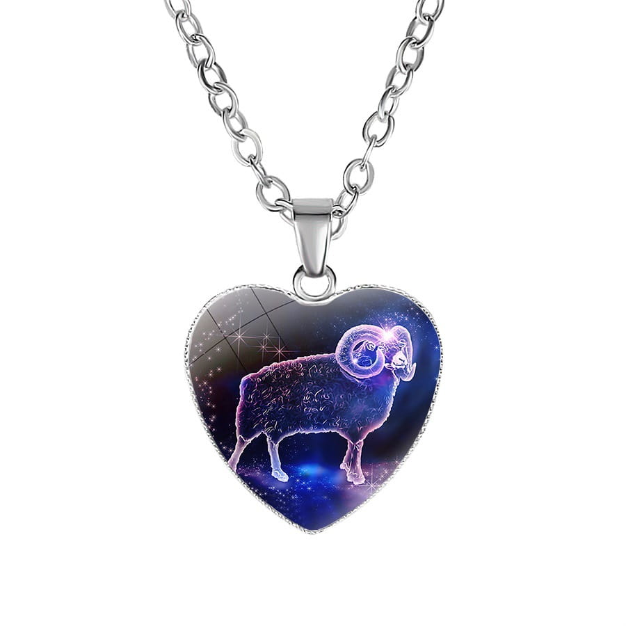 A heart-shaped pendant necklace with a silver-toned chain featuring a glossy cosmic-themed design of an aries ram in purple and blue hues against a starry background.