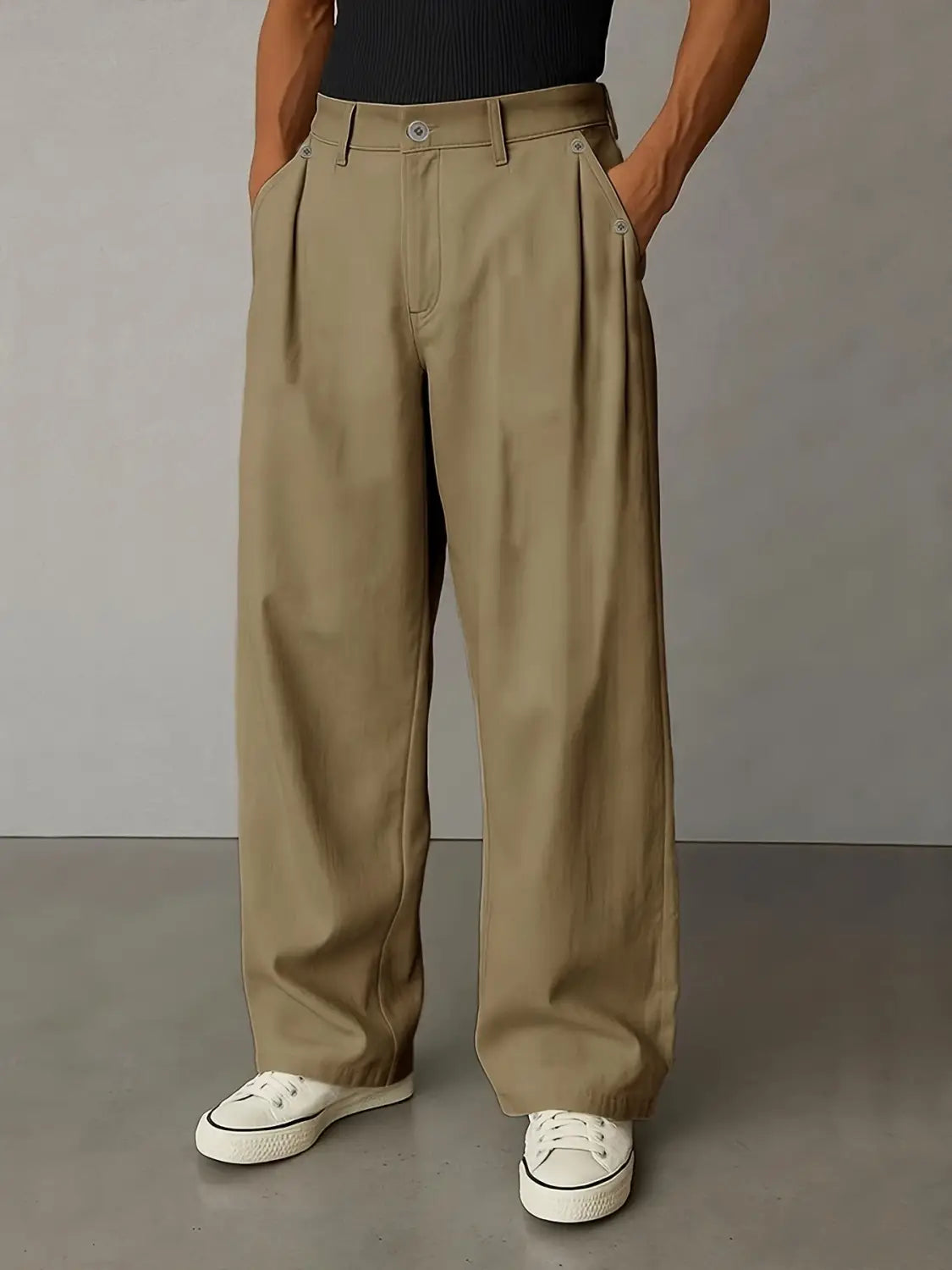 Des pantalons décontractés plissés à jambes larges de couleur kaki pour hommes, avec une coupe décontractée et des plis à l’avant réalisés dans un tissu respirant.