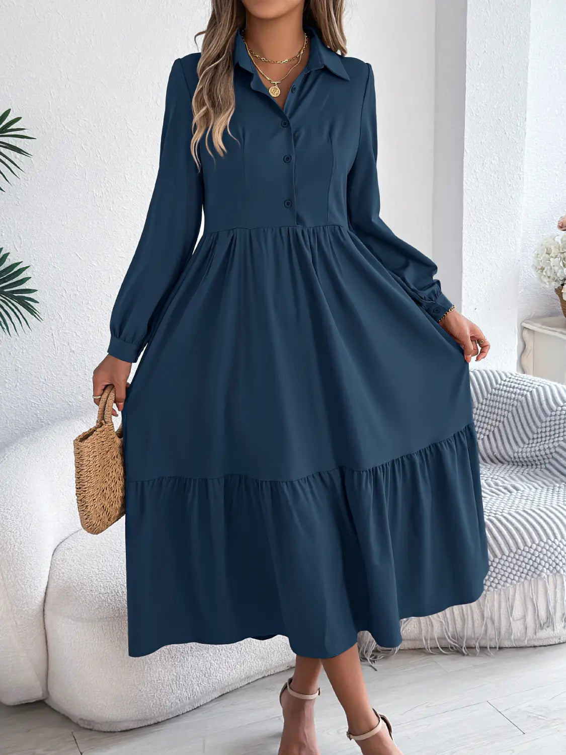 A navy blue long sleeve tiered button down midi dress featuring a subtle ruffle design.