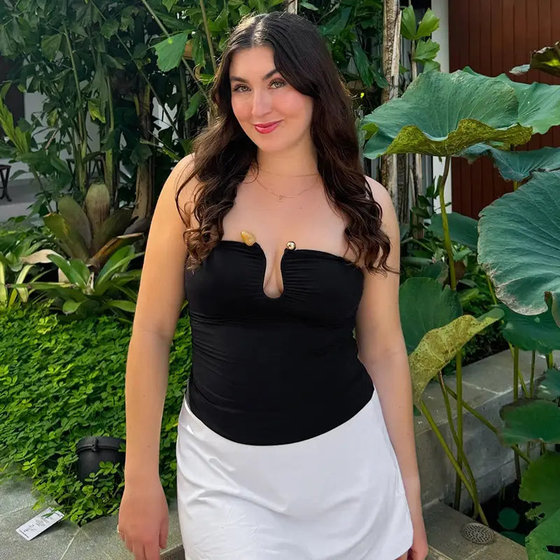 Black strapless crop top featuring a center-front keyhole cutout and gold-tone button accents.