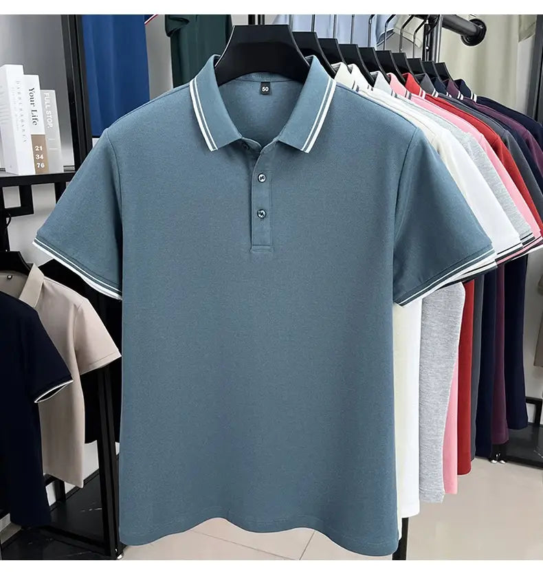 Ein hellblaues mercerisiertes Baumwoll-Poloshirt für Herren mit weißem Besatz am Kragen und an den Bündchen der Ärmel, für Sommerbekleidung konzipiert, dargestellt an einem schwarzen Kleiderbügel.