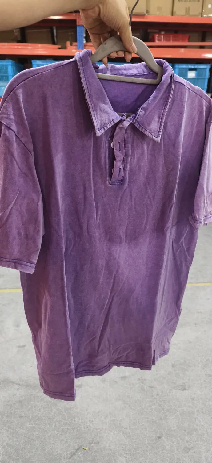 Lila ausgefranstes Baumwoll-Poloshirt mit kurzen Ärmeln, Kragen und Knopfleiste aus weichem Baumwollstoff.