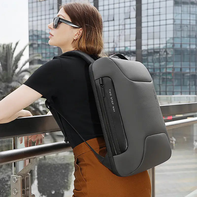 Dunkelgrauer, eleganter und moderner wasserdichter Business-Laptop-Rucksack mit USB-Anschluss und dezentem Zwei-Schritt-Van-Logo an der Seite.