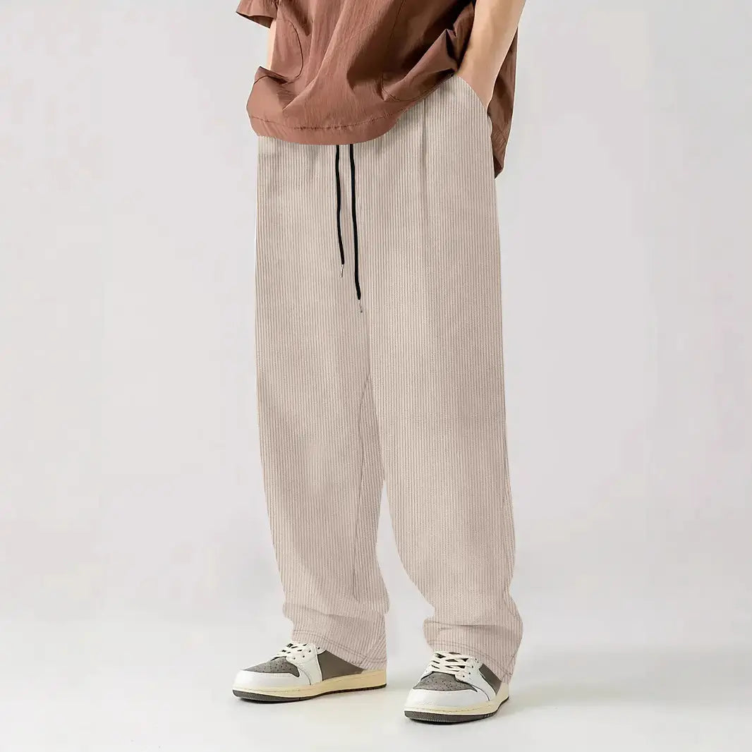 Pantalones casuales rectos de pana color beige con cordón, rayas verticales finas y cinturilla negra.
