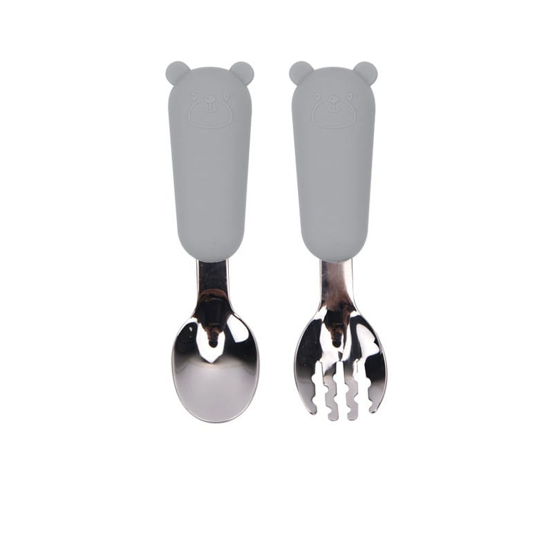Manches en silicone en forme d’ours gris sur un ensemble de cuillère et fourchette pour bébé en acier inoxydable, conçu pour les nourrissons.