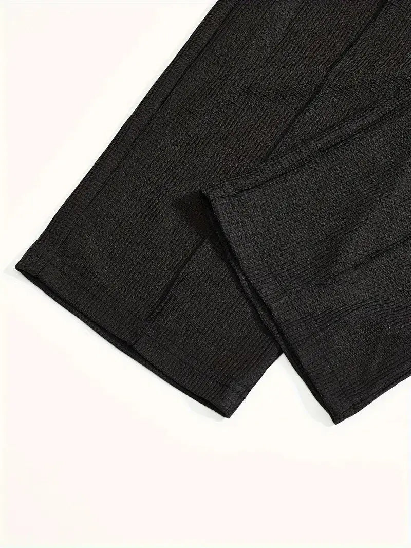 Black textured fabric with a subtle woven pattern used in the mens minimalist solid color sweatshirt jogger set.