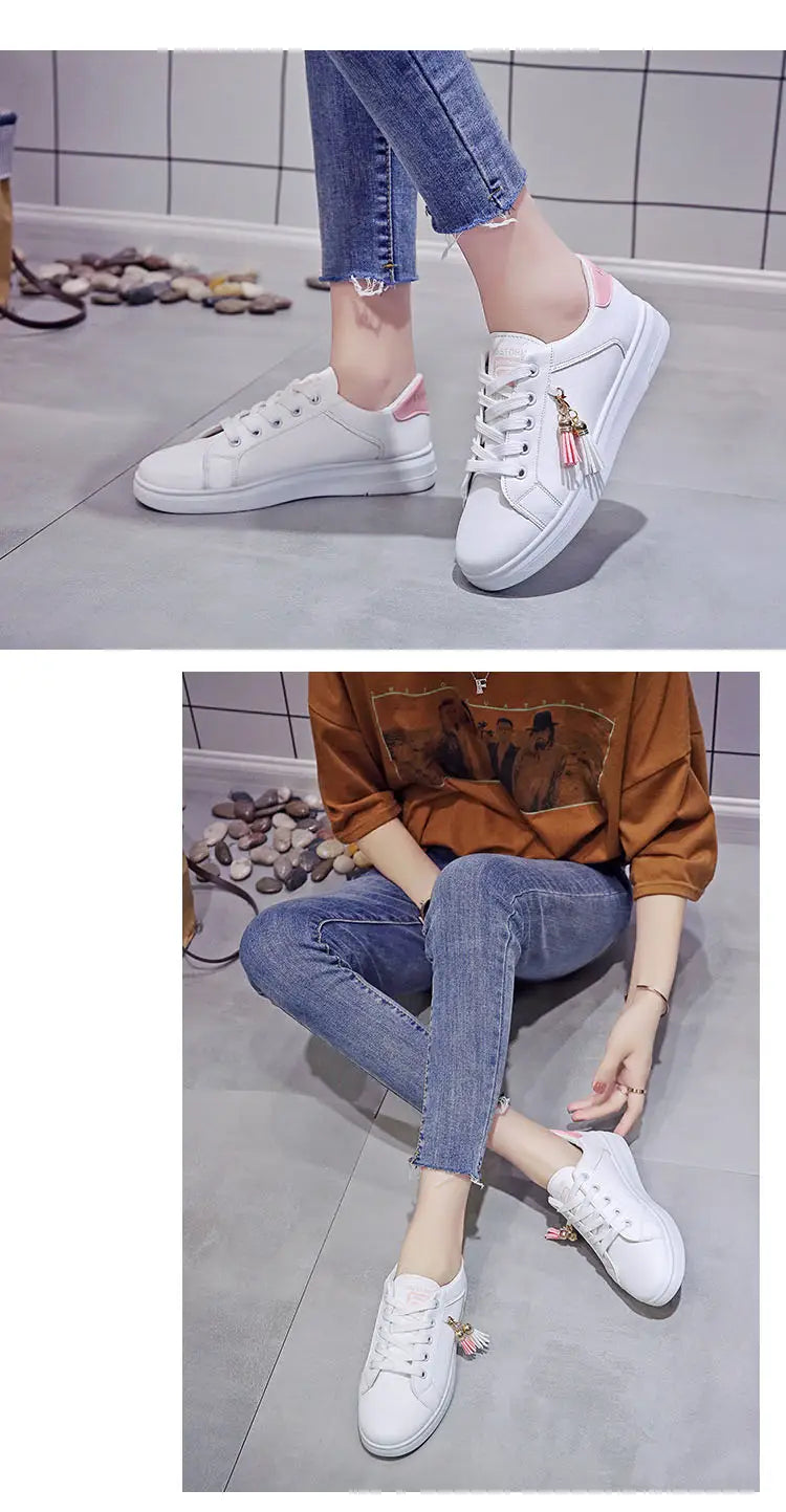 White leather low-top sneakers with breathable sports design featuring pink accents and decorative tassels on the side.