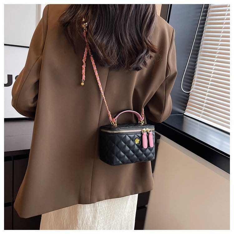 Black quilted diamond chain crossbody bag with pink pu leather handles, tassels, and gold-tone hardware.