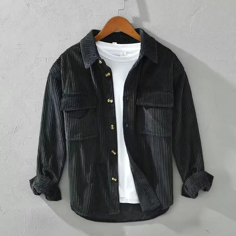 Herren-Cordhemd, schmal geschnitten, langarm, Herbstbekleidung in Schwarz mit goldfarbenen Knöpfen und zwei Brusttaschen, getragen über einem weißen T-Shirt, geeignet für Herbstbekleidung.