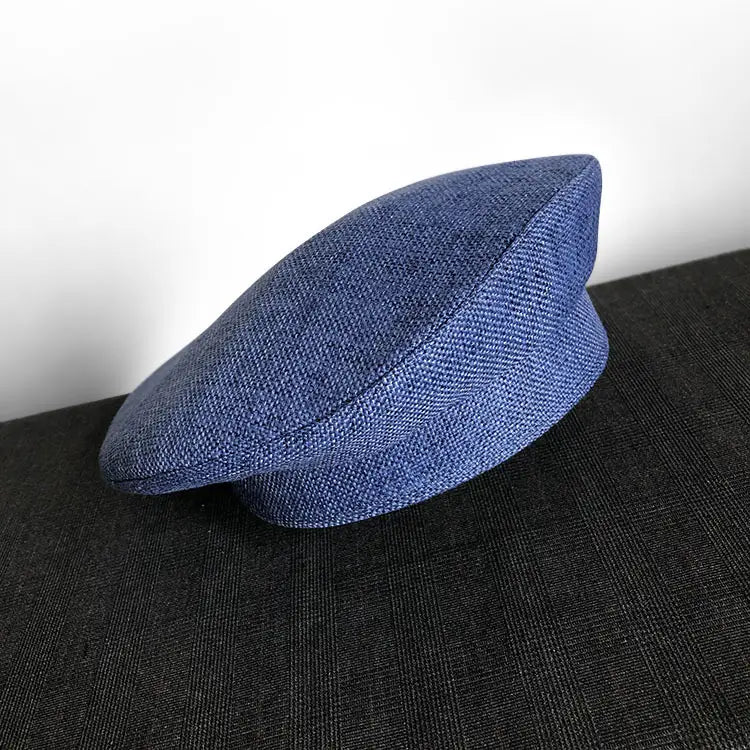 Béret en laine texturée bleu marine, avec une calotte structurée légèrement arrondie et une bordure souple à revers, conçu comme un béret noir en laine pour peintre pour femmes.