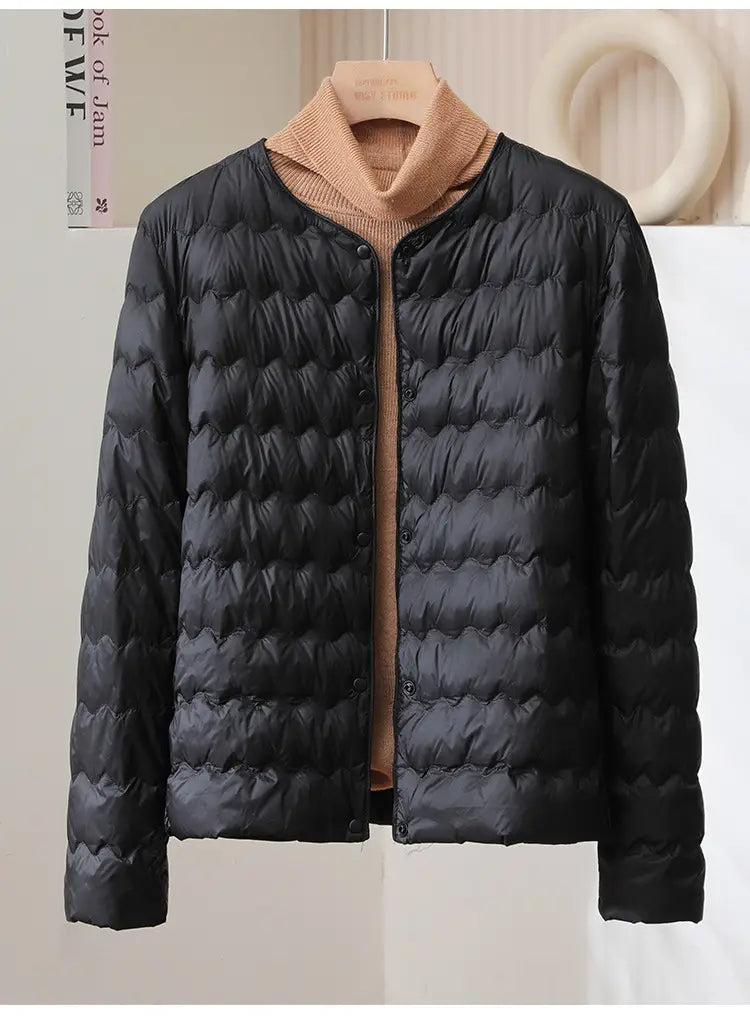 Black quilted down puff jacket with ruffled crew neck and front button closure.