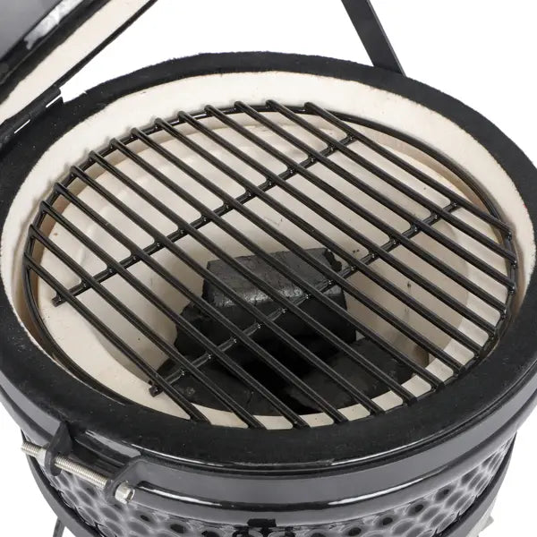 Black ceramic 13 inch Kamado charcoal grill with white interior and metal grates.
