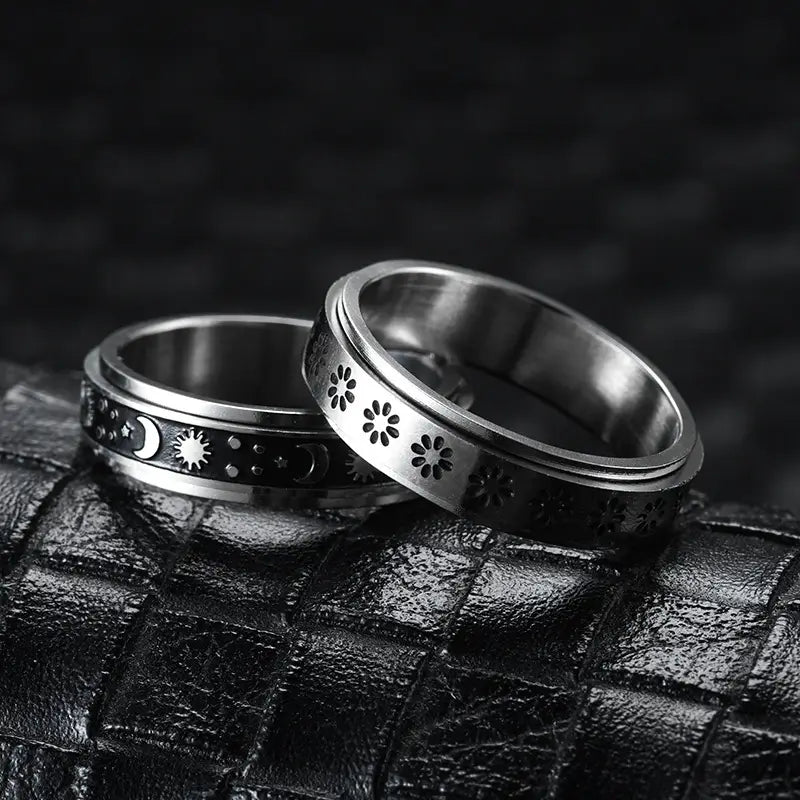 Two silver-toned stainless steel anxiety spinner rings featuring celestial motifs and floral cutouts in a celestial stainless steel anxiety spinner ring set.