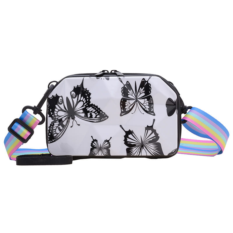 Transparent white mini suitcase crossbody bag featuring black butterfly silhouettes and a rainbow-striped strap.