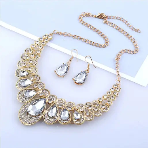 Vintage gold teardrop crystal bridal jewelry set featuring a gold-toned necklace with cascading teardrop-shaped clear crystals in an ornate jeweled frame.