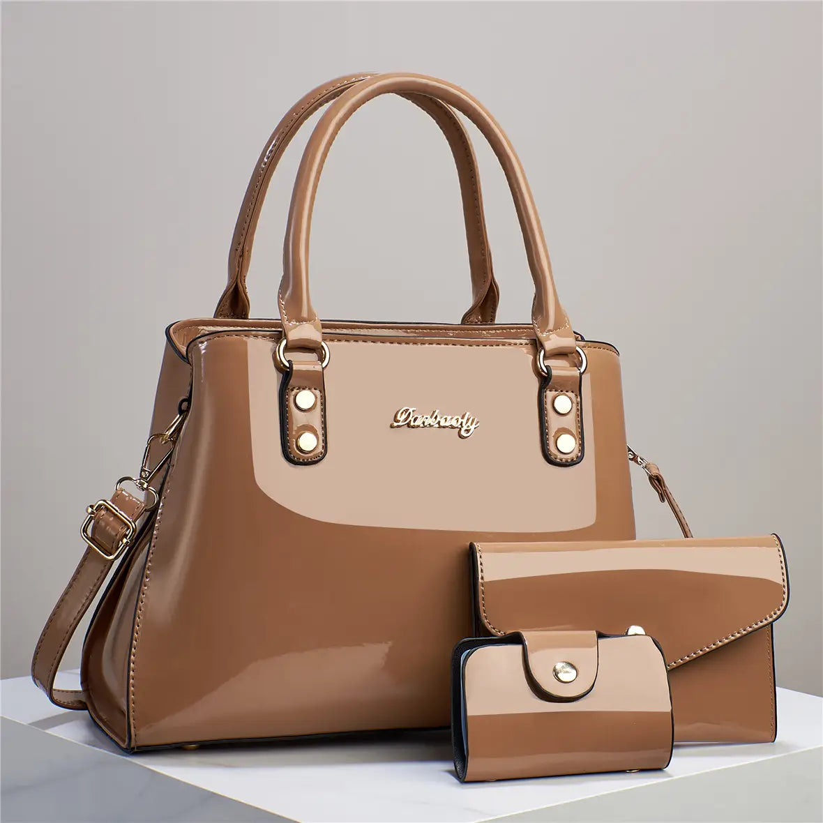 Glossy patent leather 3-piece handbag and wallet set in tan featuring a handbag, matching clutch, and coin purse with gold-tone hardware accents.
