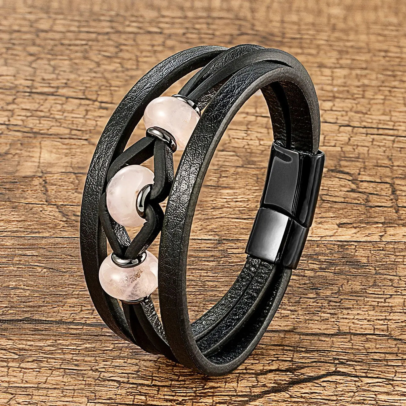 Bracelet en cuir noir à cordon, avec trois perles en pierre naturelle rose quartz et une fermeture magnétique.