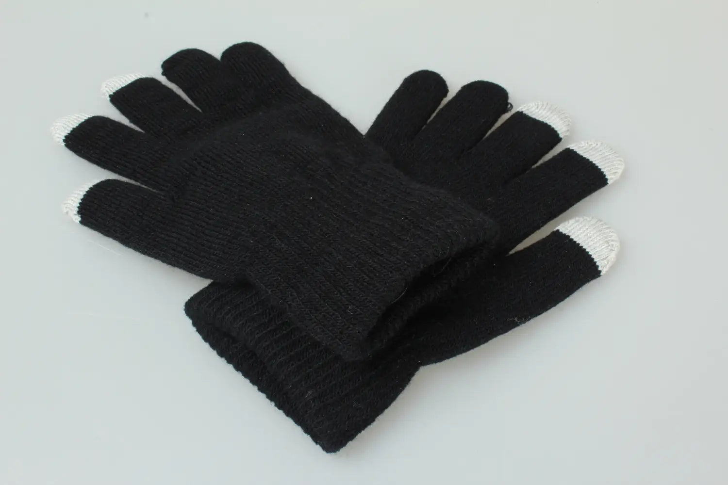 schwarze gestrickte Touchscreen-Winterhandschuhe für Damen und Herren mit weißen Fingerspitzen, von der Rückseite gezeigt