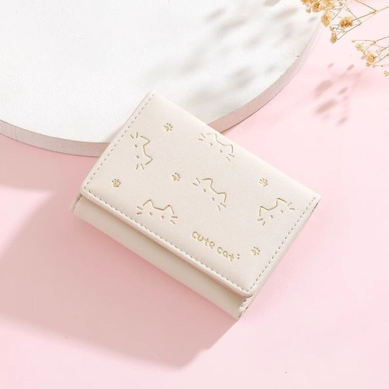 A cream-colored leather women’s small folding wallet featuring gold-embossed cat faces and paw prints.