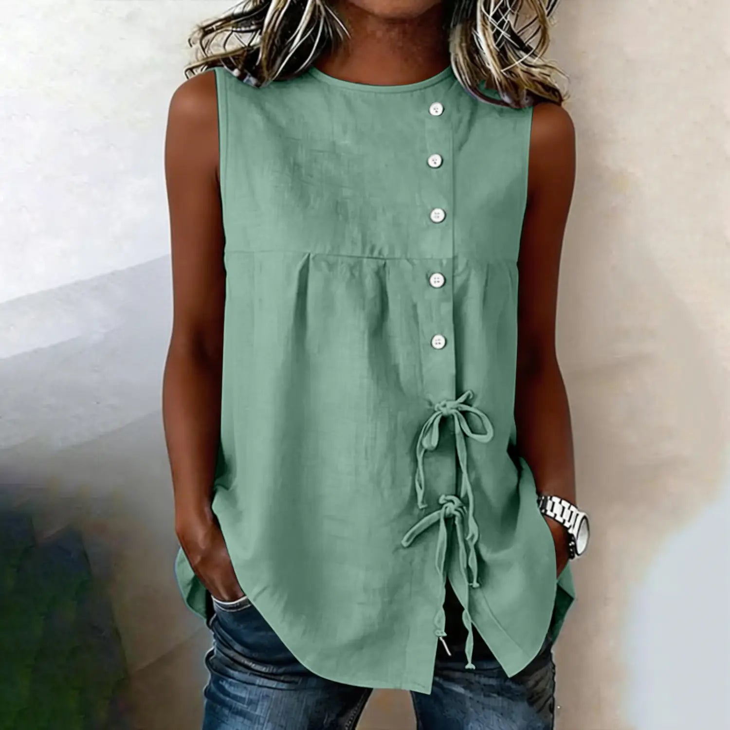 A sage green sleeveless tie side button down blouse made of lightweight fabric suitable for casual wear.