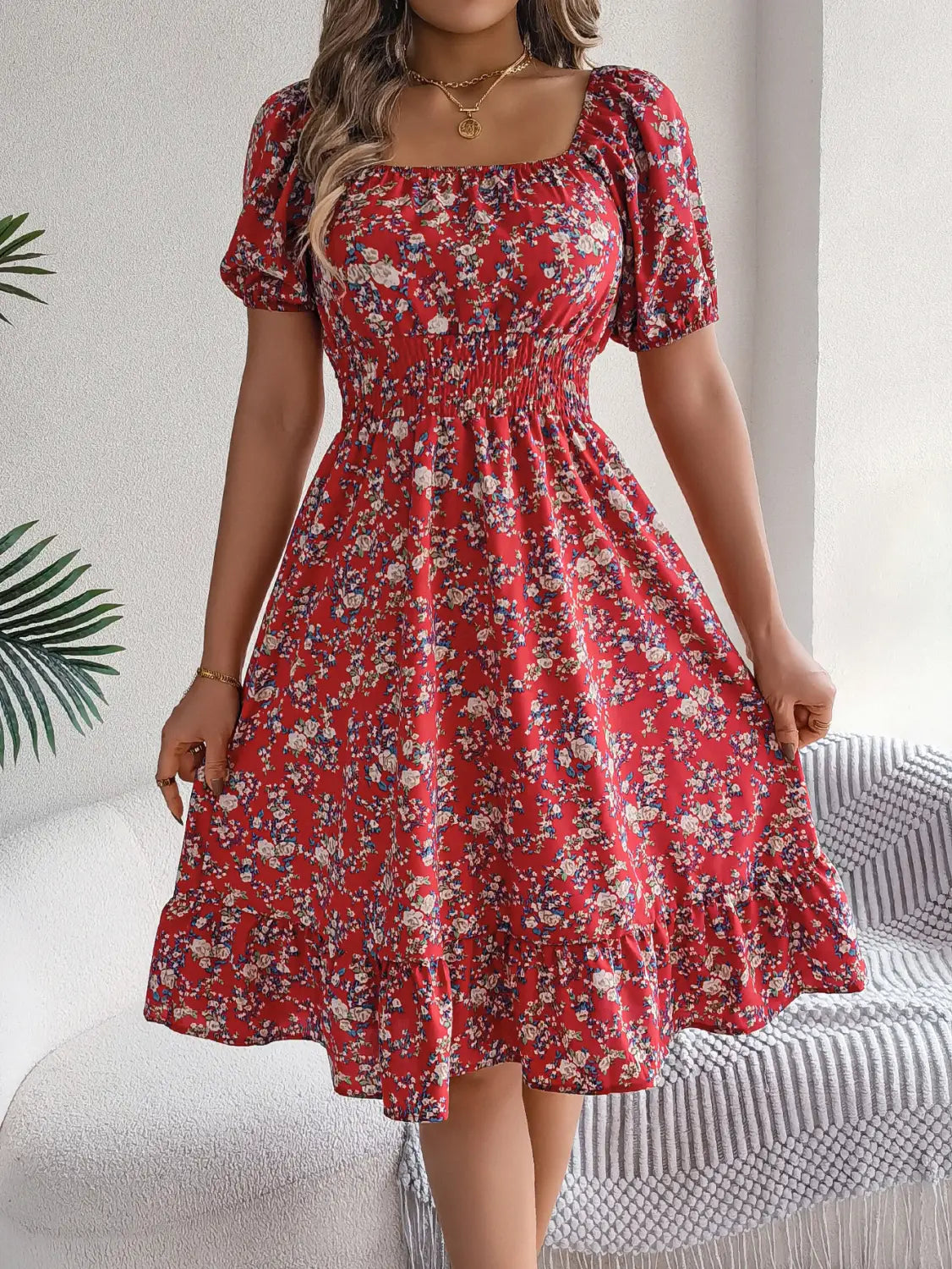 Robe d’été à imprimé floral rouge avec encolure carrée et manches courtes bouffantes.
