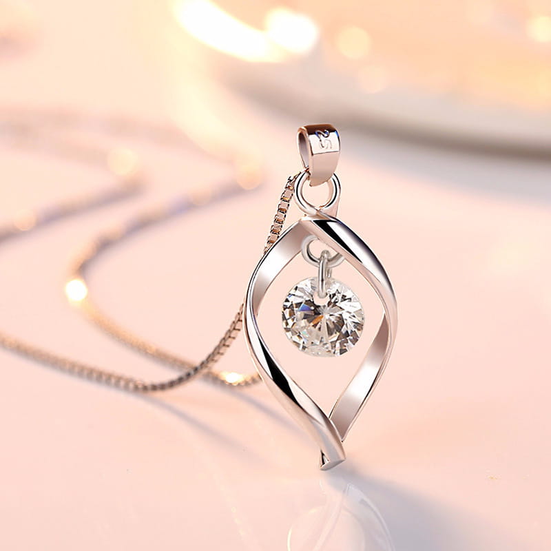 Elegant zircon twist teardrop pendant necklace in silver featuring a swirling openwork design with a central clear crystal.