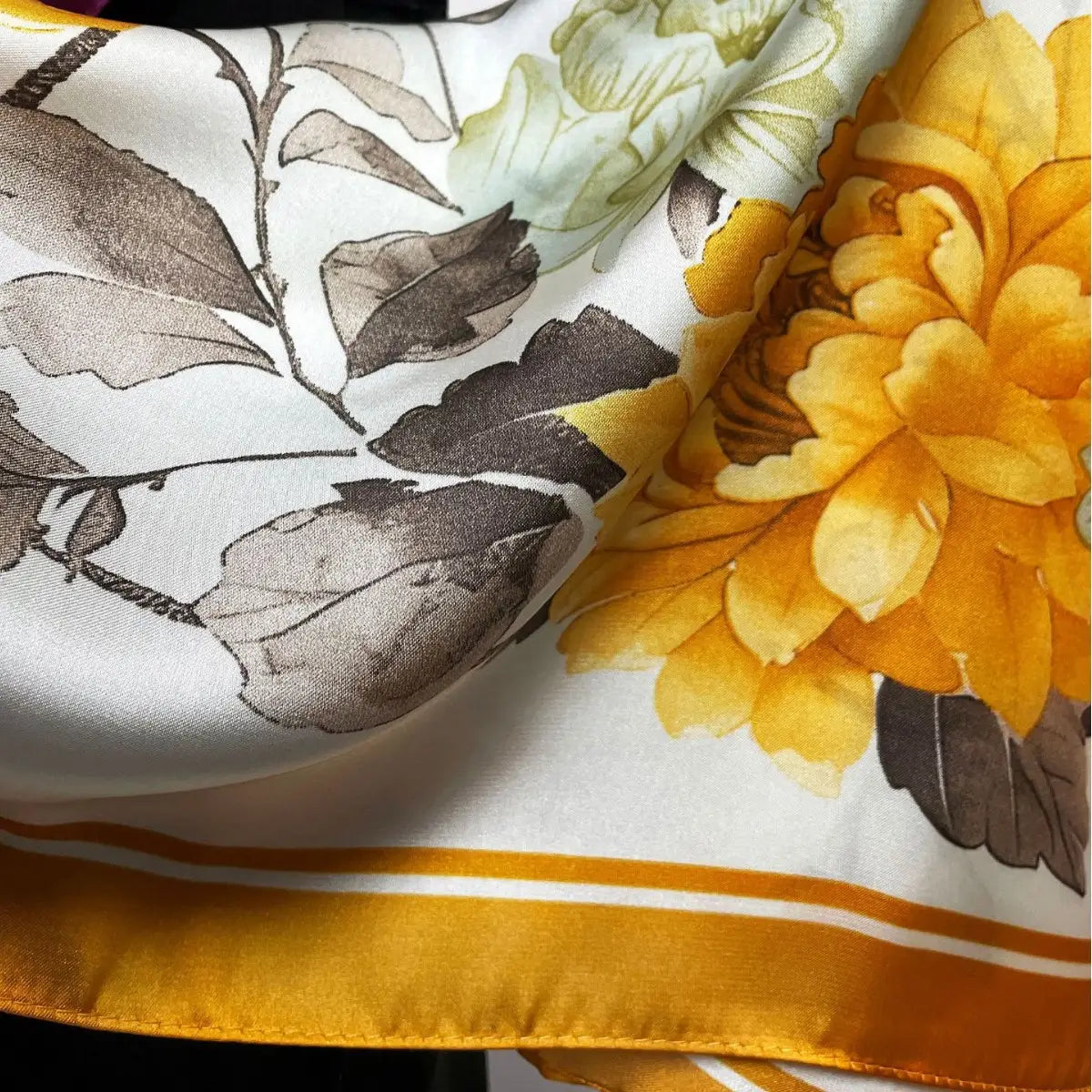 A luxurious white silk floral square scarf featuring a vibrant yellow peony and delicate gray botanical illustrations with an elegant gold satin border.