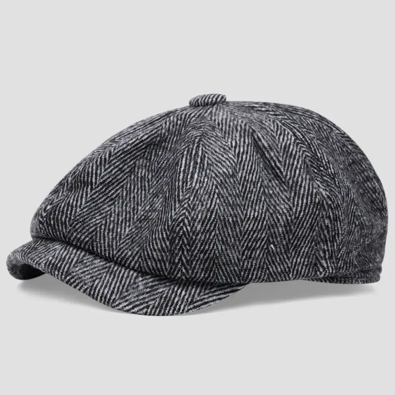 A classic gray herringbone-patterned wool flat cap with an octagonal beret eight-panel design and a slightly curved brim.