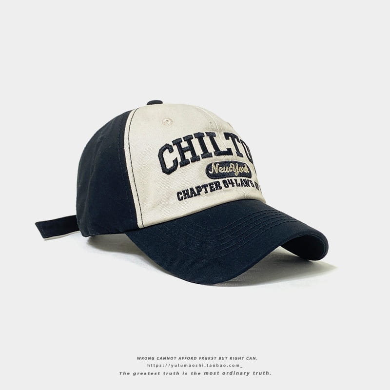 Casquette de baseball rétro à empiècements contrastés deux tons marine et crème, avec broderie « Chilton » et un petit écusson ovale indiquant « New York ».