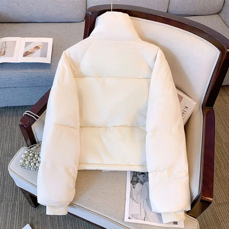 Chaqueta acolchada tipo puffer de algodón para mujer en color crema, con cuello alto y mangas largas, diseñada para la ropa exterior de invierno.