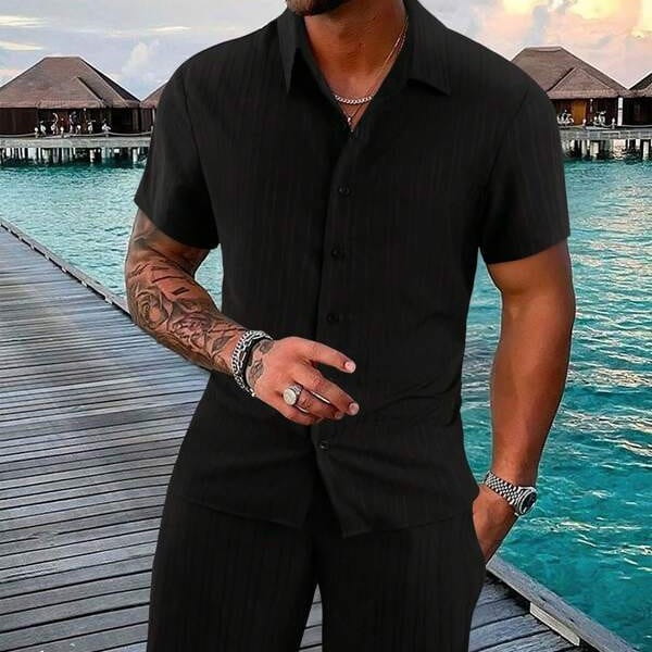 Black men’s ribbed short-sleeved button-up shirt with a collar and subtle texture from the beach set.