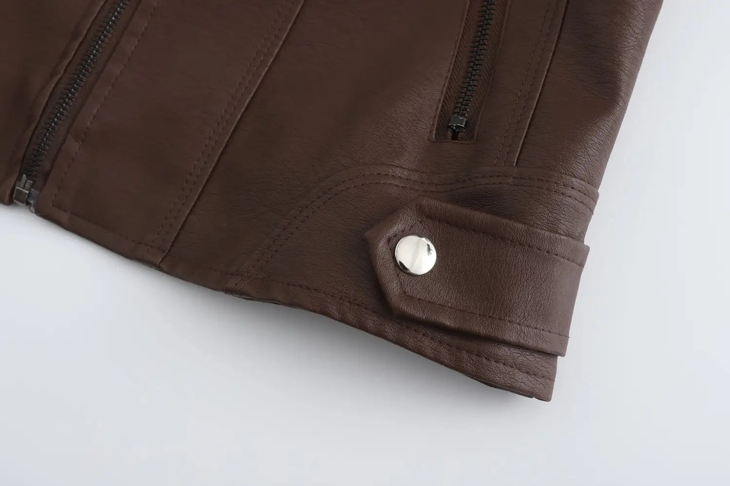 Veste motard en faux cuir marron avec col montant, présentant des fermetures éclair noires et un bouton argenté.