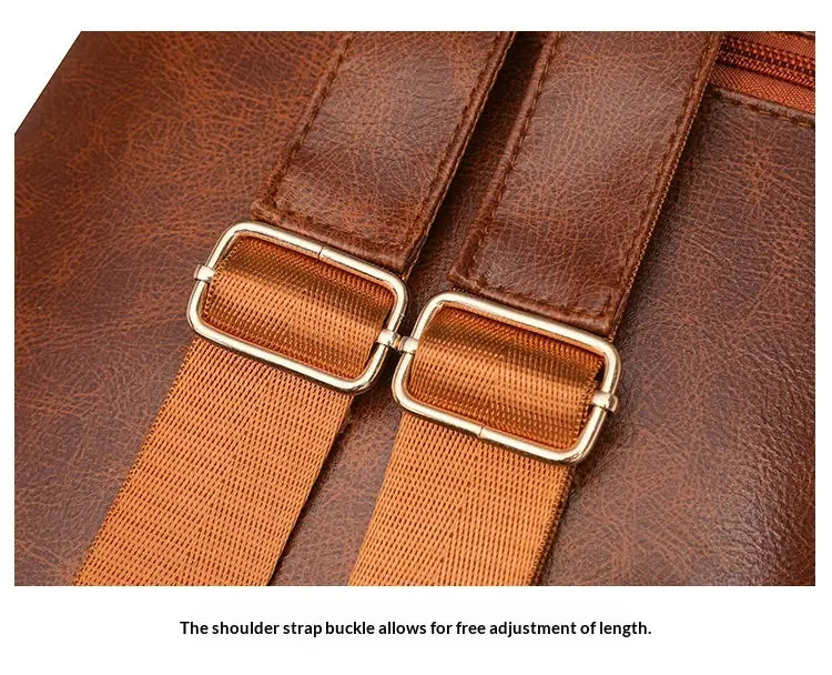 Brown faux leather shoulder strap with gold-tone metal buckles and adjustable woven fabric sections on the back side of a faux leather women’s large capacity commuter backpack.