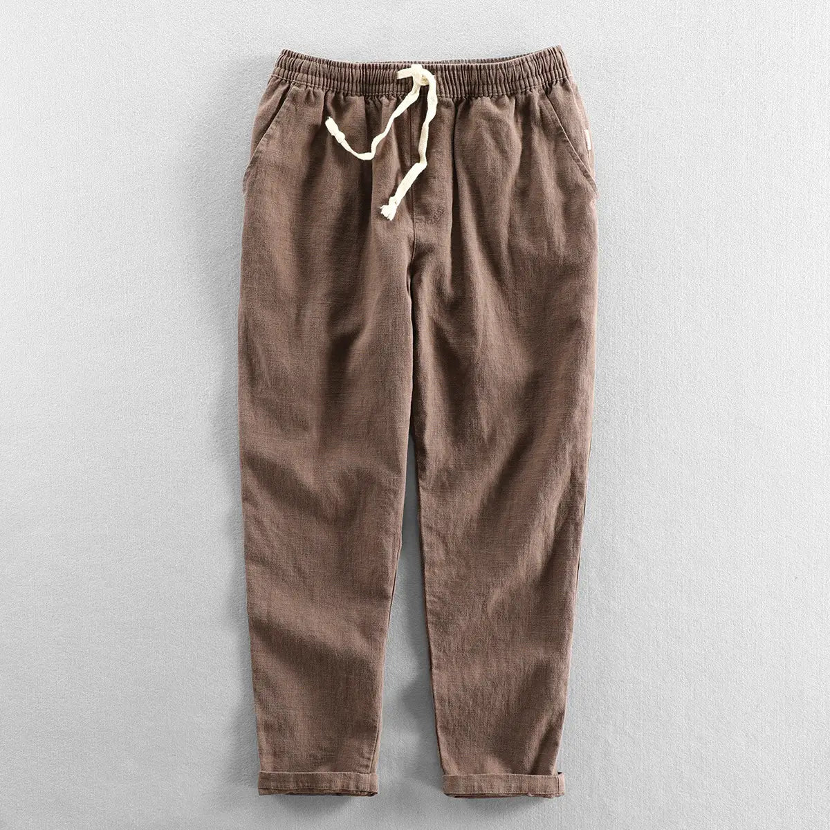 Men’s relaxed fit drawstring linen joggers in brown with rolled cuffs and a drawstring waist.
