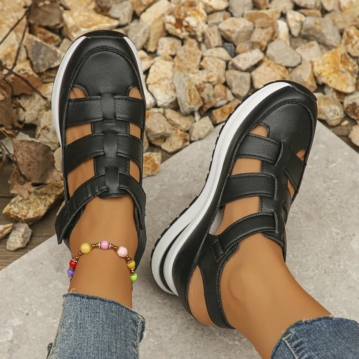 Breathable hollow wedge platform sandals in black leather look feature a braided strap design with velcro straps and white soles.