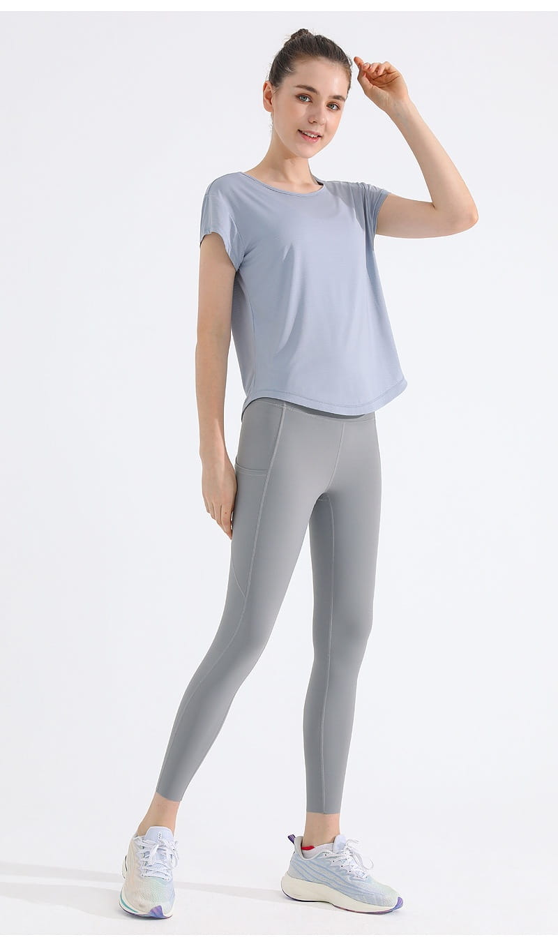 Schnelltrocknendes Mesh-Sportshirt für Damen, Yoga-Top, in sanftem Hellgrau mit kurzen Ärmeln, entspannter Passform und dezenten Details an den Seiten-nähten.