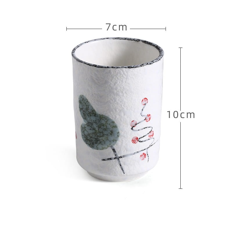 White ceramic Japanese ceramic mug with textured surface and hand-painted green leaf and pink berry design for tea drinking 250ml capacity