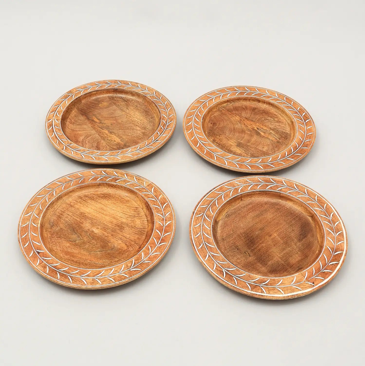 Set aus vier handgeschnitzten Holz-Tischsets mit warmem natürlichem Holz-Finish und zarten, weiß gemusterten Blatträndern, gestaltet als 13 Zoll handgefertigte Platzsets.