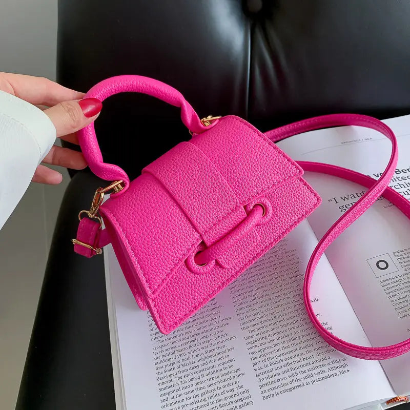Leuchtend pinke, strukturierte Mini-Handtasche aus Kunstleder mit goldfarbenen Beschlägen und passendem verstellbarem Riemen, benannt als Ketten-Umhängetasche Mini aus Kunstleder.