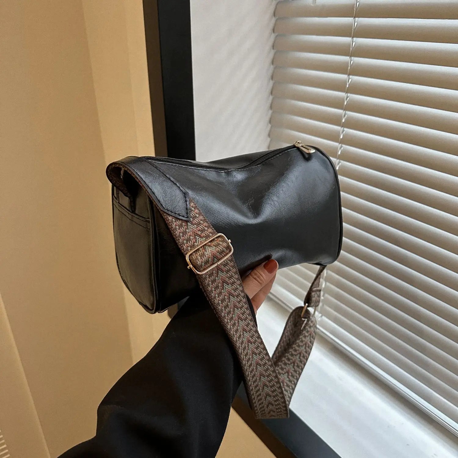 Retro leather crossbody bag in black faux leather with a textured brown woven strap and gold-tone hardware.