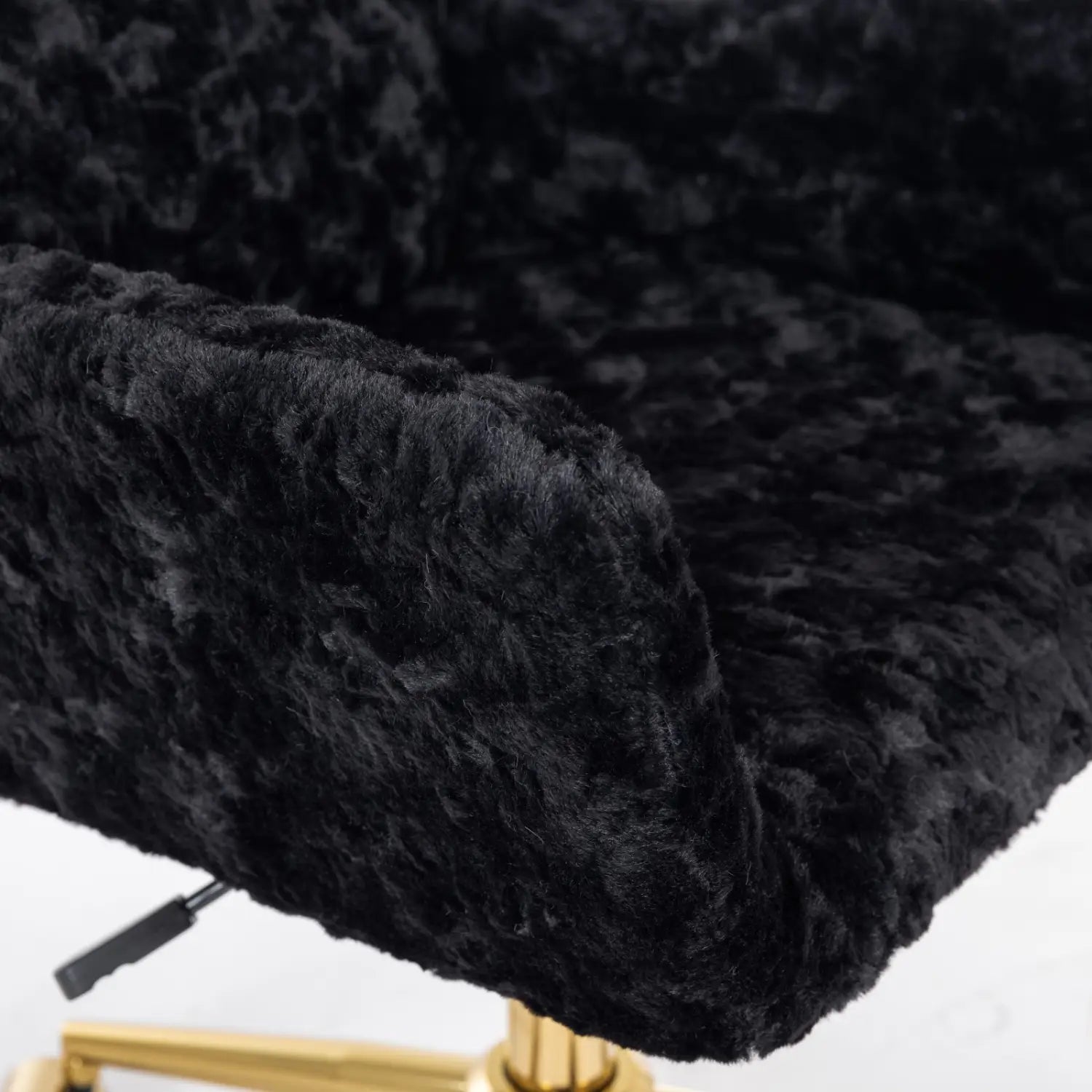 Chaise de bureau en fausse fourrure noire, avec une surface moelleuse et texturée ainsi qu’une base de ton doré, pour une assise élégante au travail.