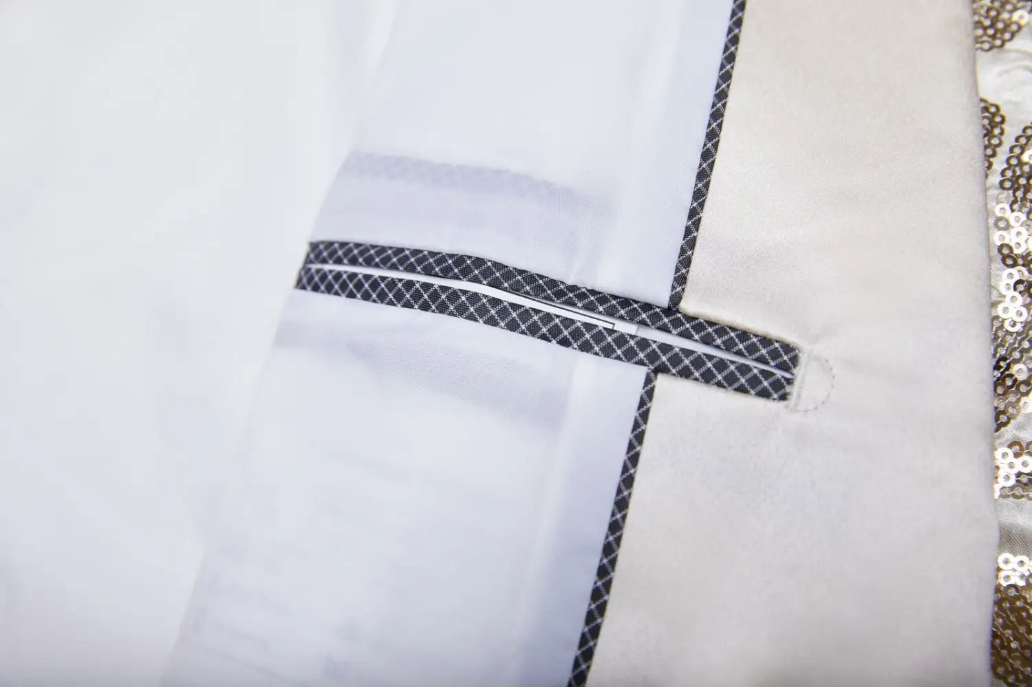 White garment with black geometric-patterned trim and zipper detail paired with a gold sequin mens suit jacket retro floral blazer.
