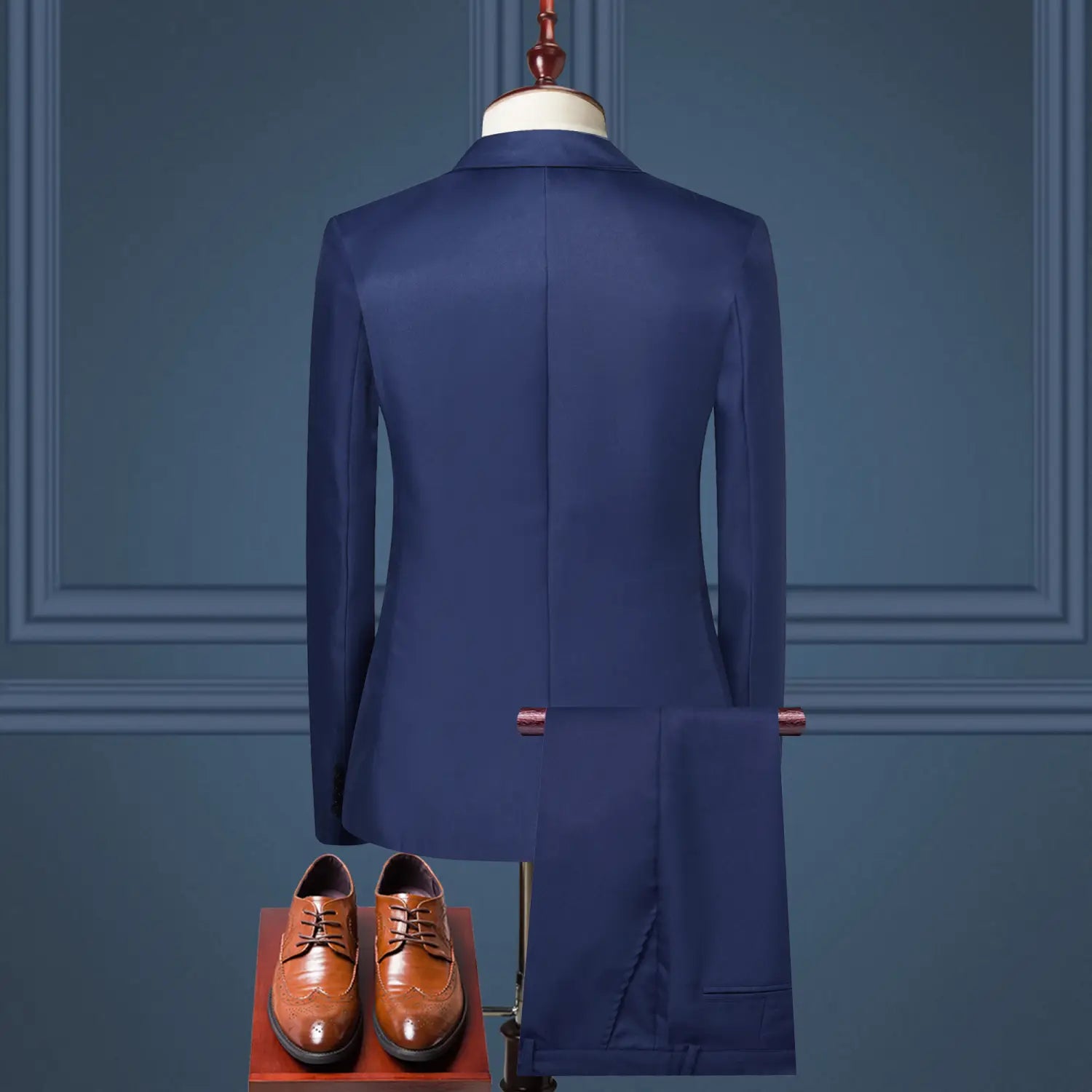 Navy blue tailored men solid color two piece leisure suit with matching trousers displayed on a mannequin paired with brown leather dress shoes.