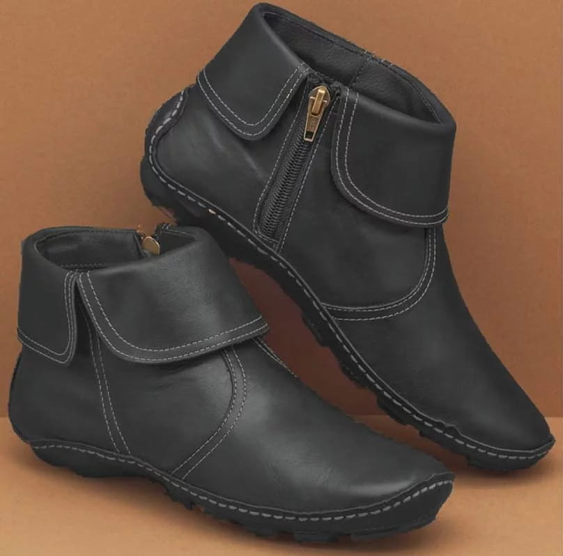 Schwarze Damenleder-Ankle-Boots mit weißer Steppnaht und goldfarbenen seitlichen Reißverschlüssen.
