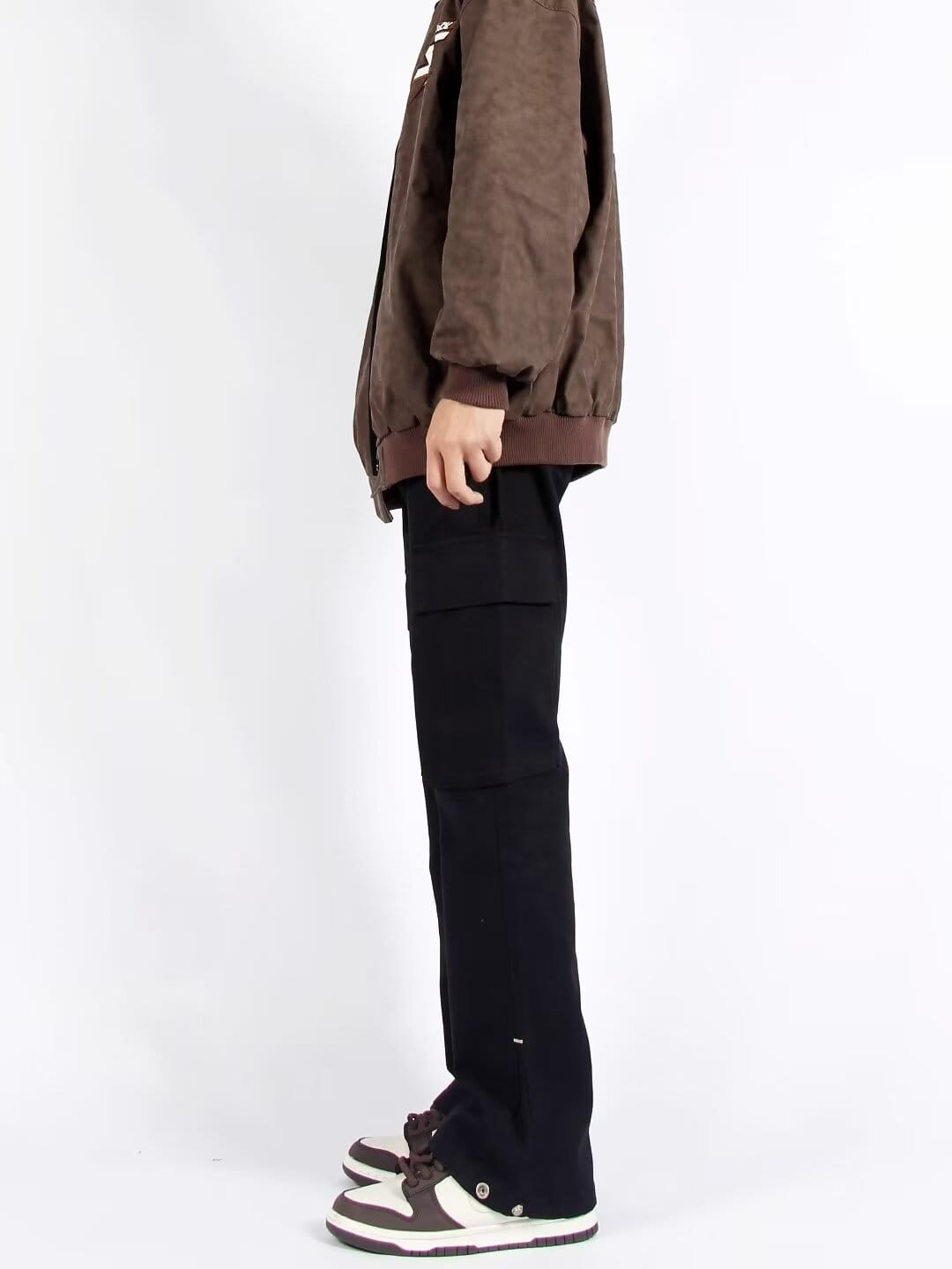 Chaqueta bomber de pana color marrón con puños y bajo acanalados, combinada con pantalones cargo rectos de pierna recta con múltiples bolsillos.