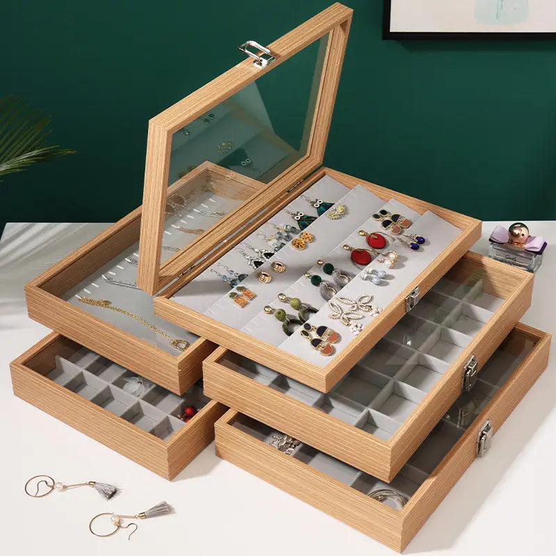 Stacked rosewood jewelry display box with glass lid and multiple drawers featuring gray felt-lined compartments for organizing earrings necklaces and accessories.