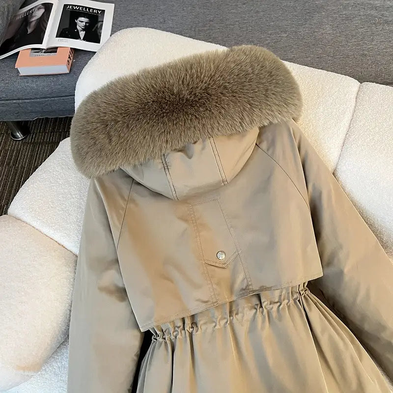 Parka matelassée à capuche avec col de fourrure beige, capuche doublée de fourrure marron clair duveteuse et taille resserrée.